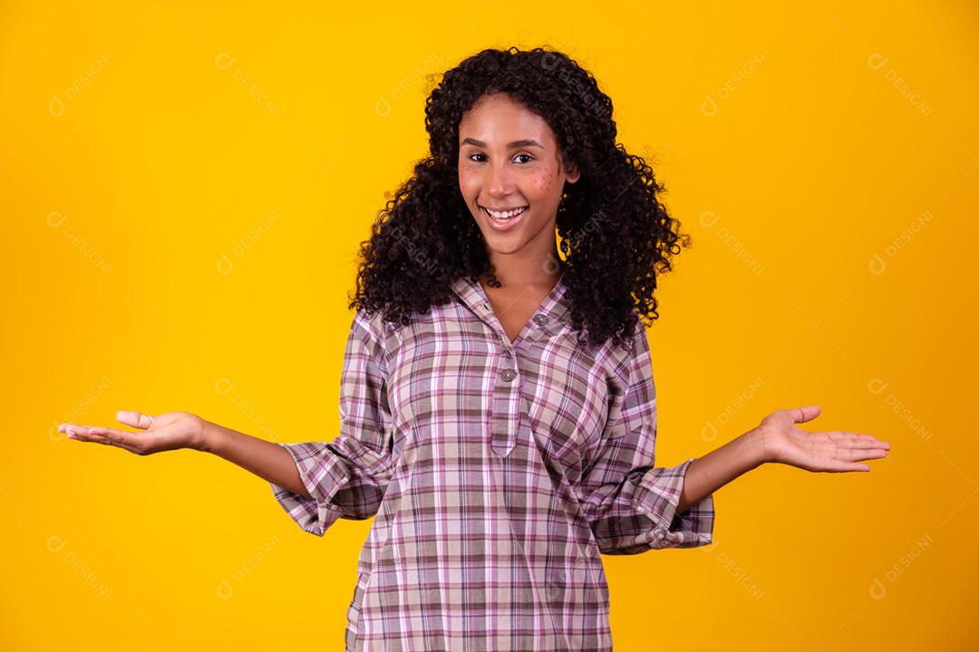 Mulher afro vestida com roupa de festa junina apontando para o lado.