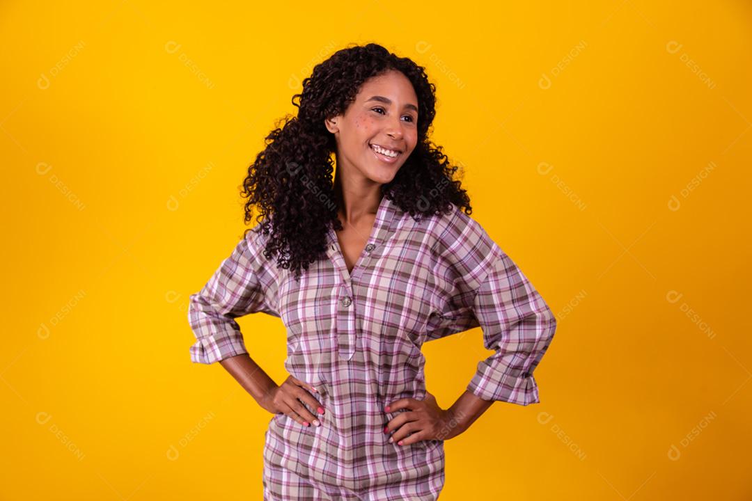 Mulher afro vestida com roupas de festa junina e cabelo amarrado por maria