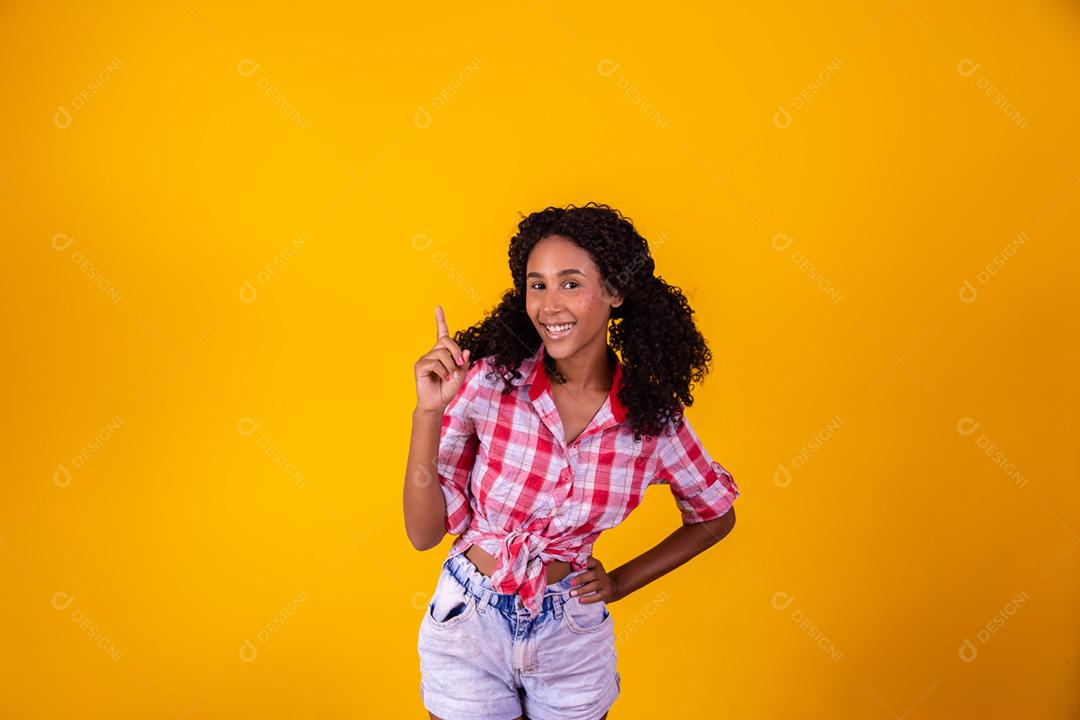 Mulher afro vestida com roupa de festa junina apontando