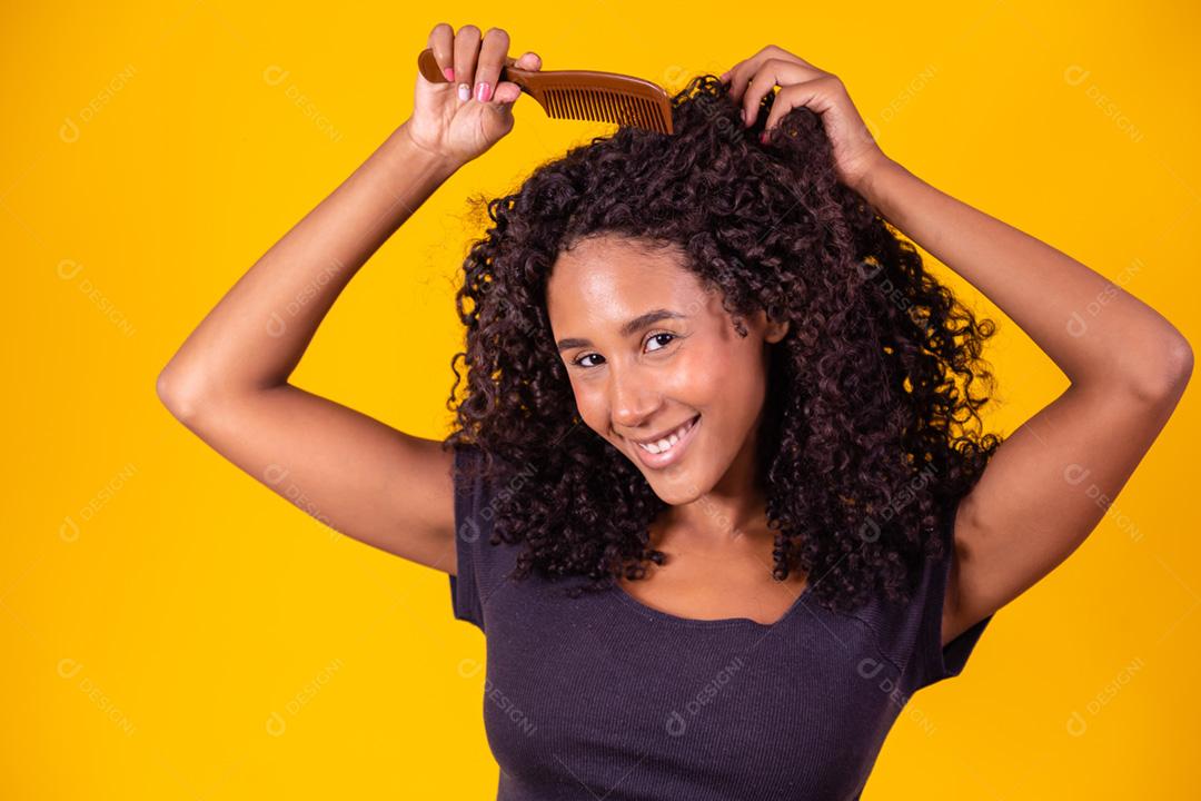garota afro penteando o cabelo com pente