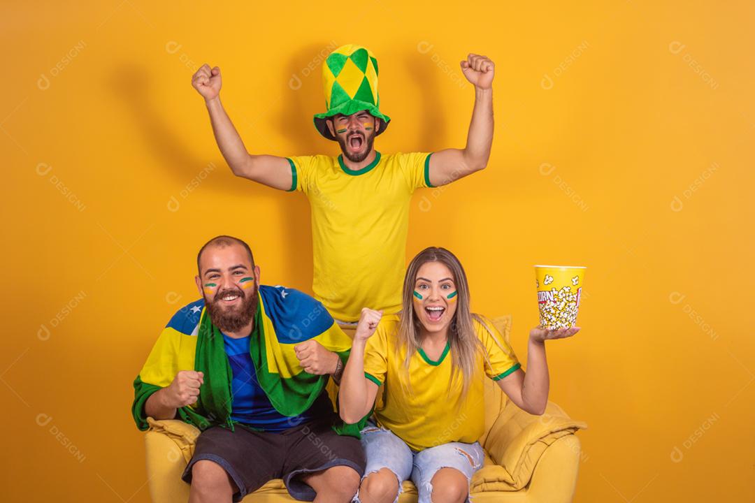 Grupo de amigos assistindo jogo de futebol na televisão, celebrando