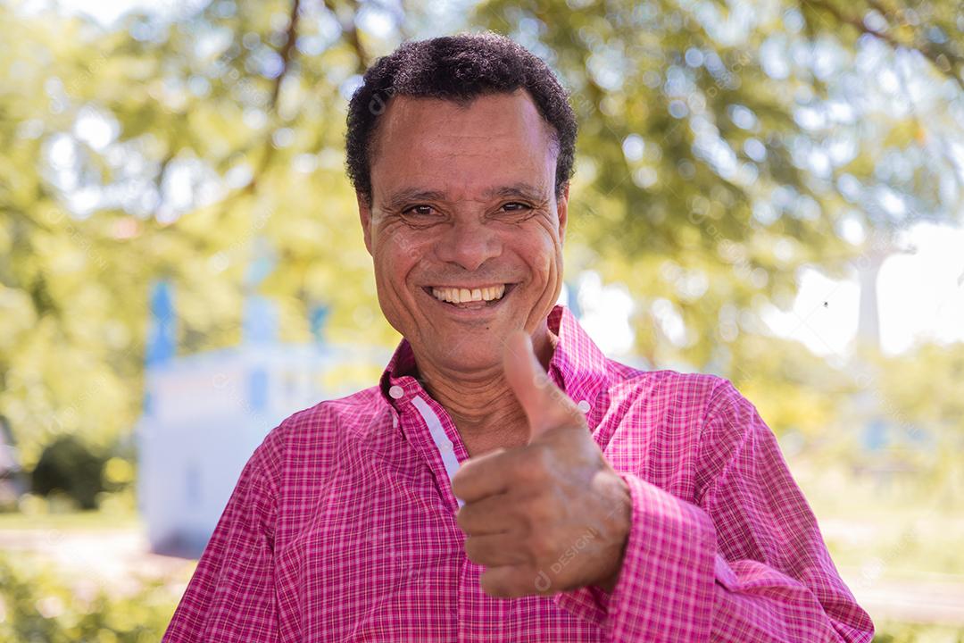 Homem afro idoso olhando para a câmera com polegares para cima