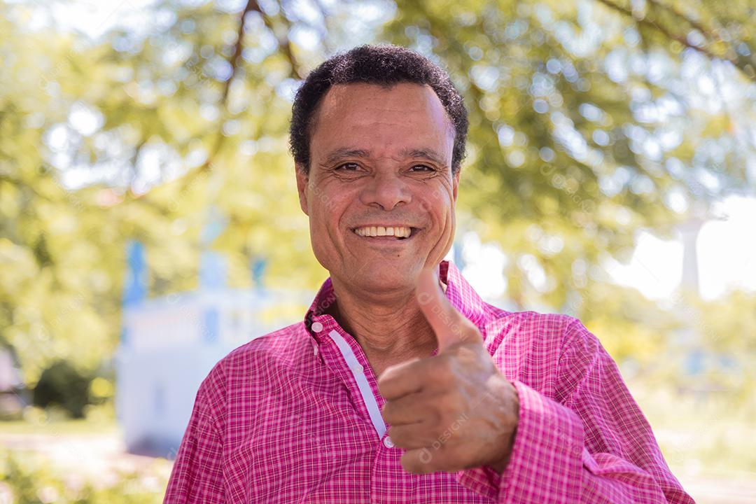 Homem afro idoso olhando para a câmera com polegares para cima