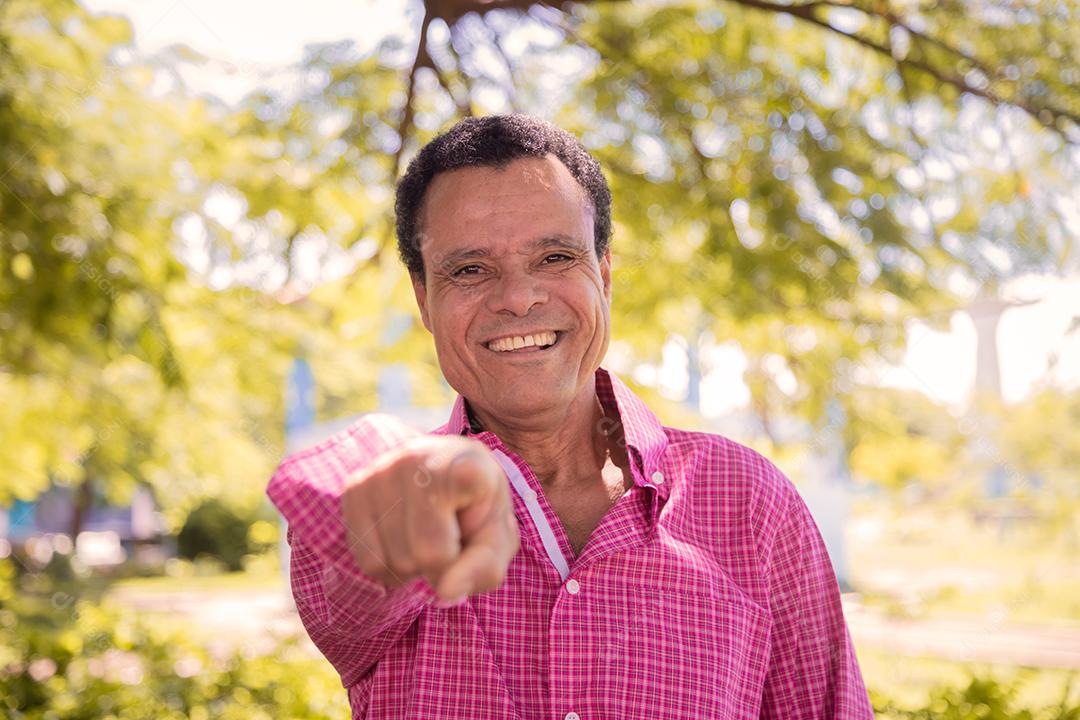 Retrato de homem agricultor mais velho feliz apontando para a frente.