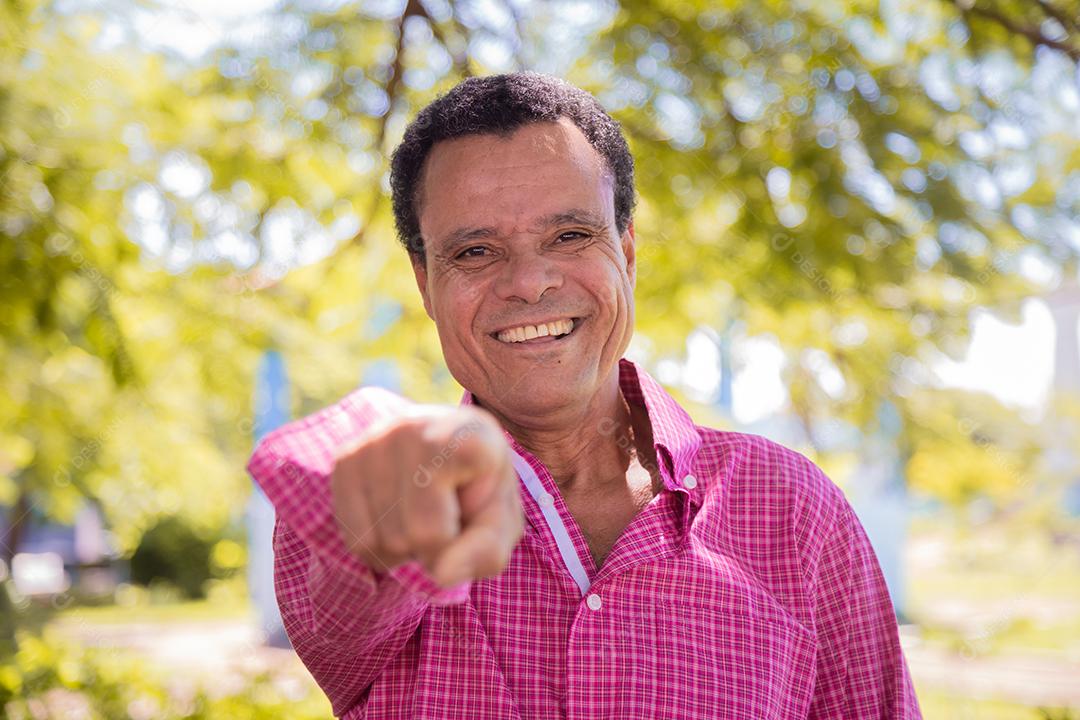 Retrato de homem agricultor mais velho feliz apontando para a frente.