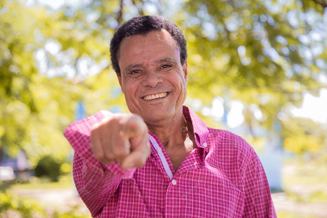 Retrato de homem agricultor mais velho feliz apontando para a frente.