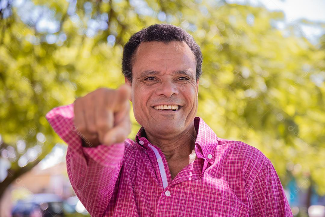 Retrato de homem agricultor mais velho feliz apontando para a frente.