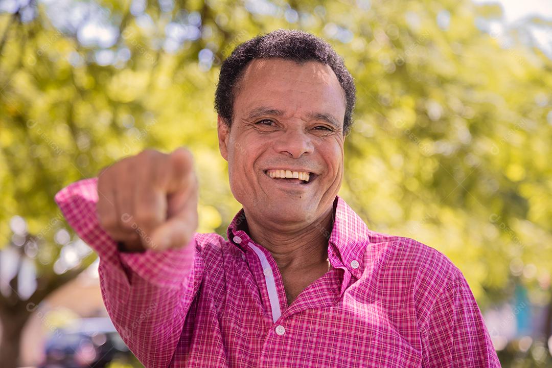 Retrato de homem agricultor mais velho feliz apontando para a frente.