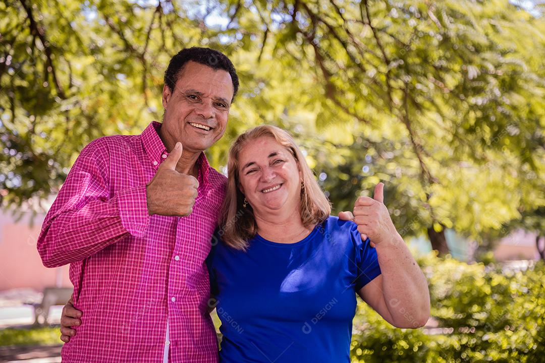 Casal de namoro mais velho com polegares para cima sorrindo