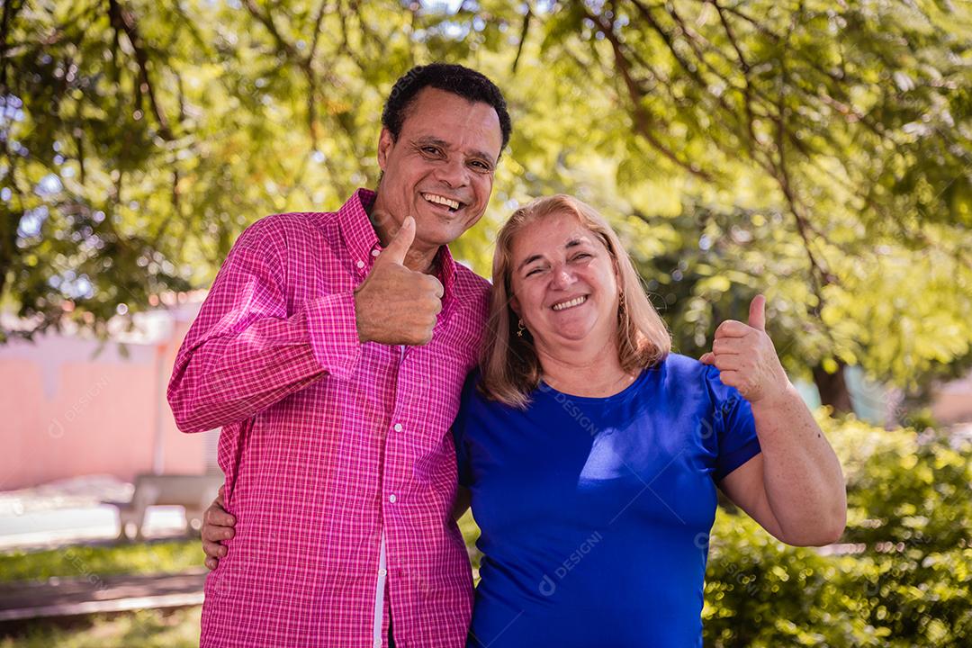 Casal de namoro mais velho com polegares para cima sorrindo