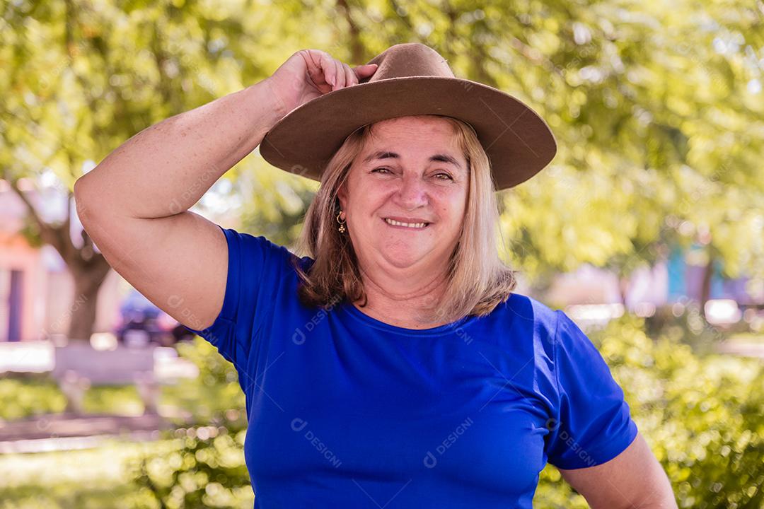 Retrato de um lindo agricultor sorridente. Mulher na fazenda em dia de verão. Atividade de jardinagem. Mulher idosa brasileira.