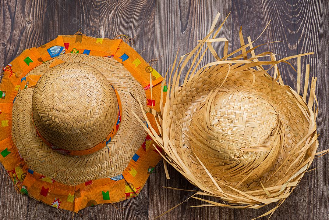 Chapéu de palha para o festival de junho visto de cima em fundo de madeira.