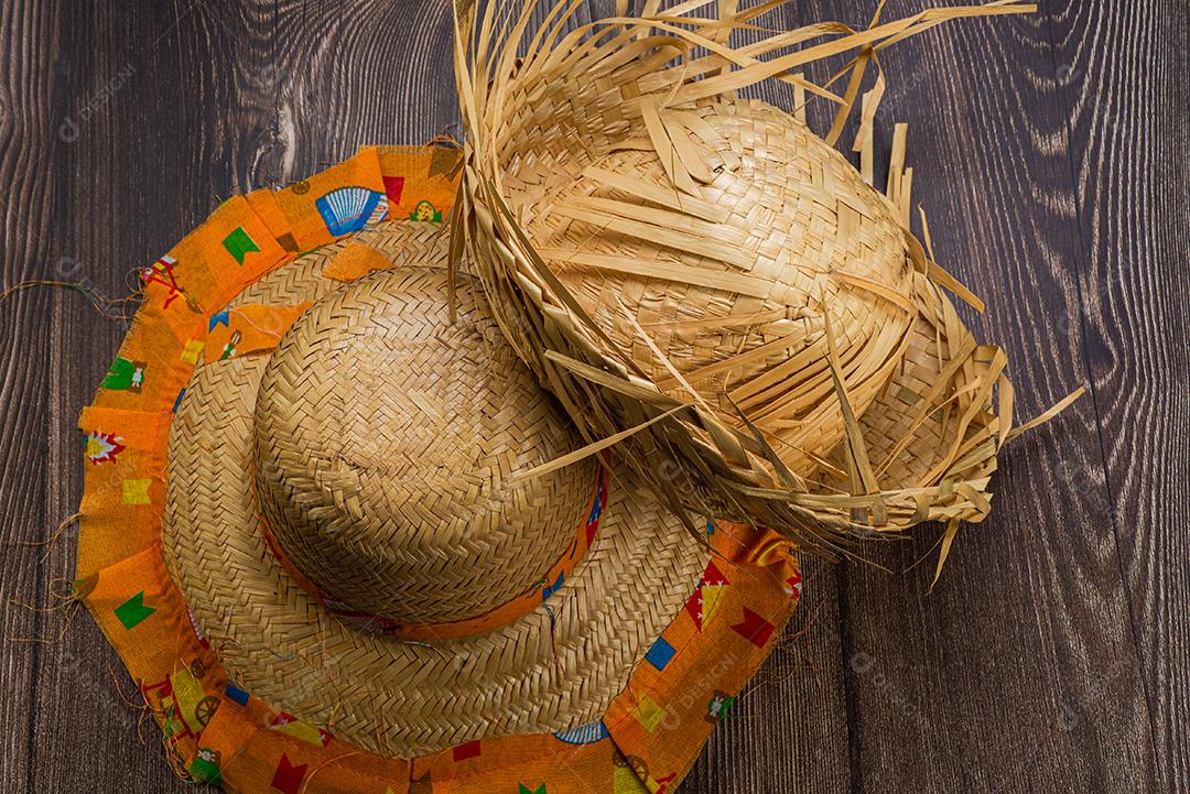 Chapéu de palha para o festival de junho visto de cima em fundo de madeira.