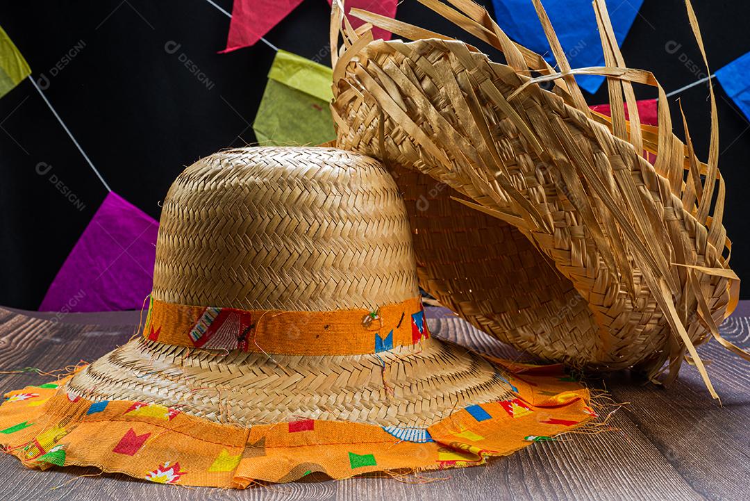 Chapéu de palha para o festival de junho visto de cima em fundo de madeira.