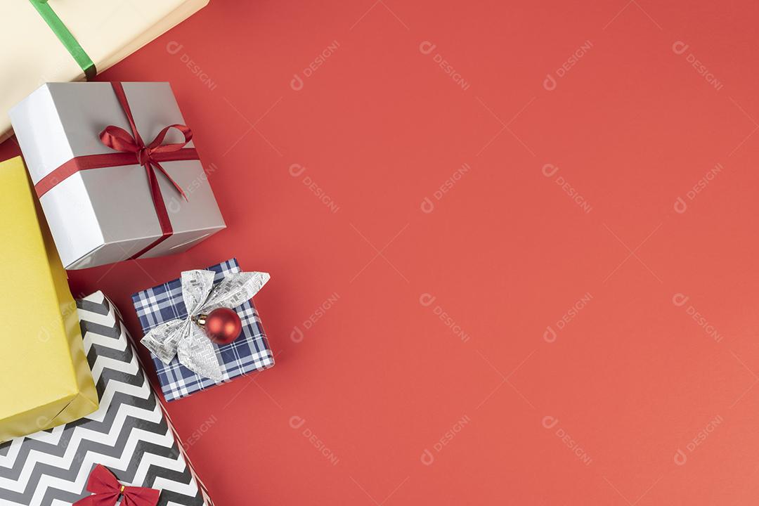 Caixas de presente e bolas de natal sobre fundo vermelho