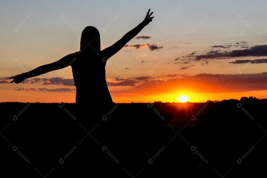 Belo pôr do sol com a silhueta de uma garota simbolizando a paz