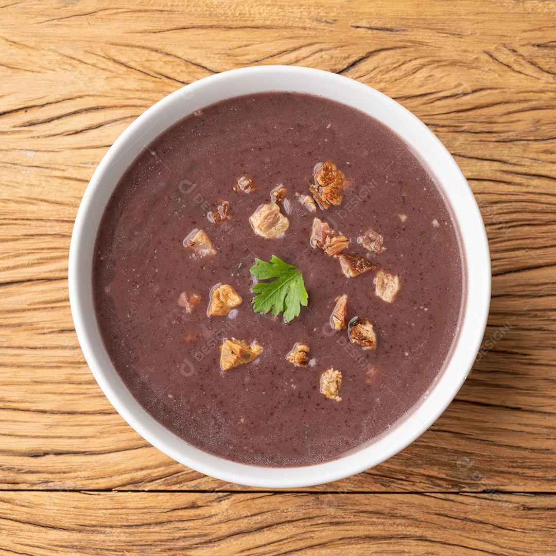 Sopa de feijão preto em uma tigela sobre a mesa de madeira
