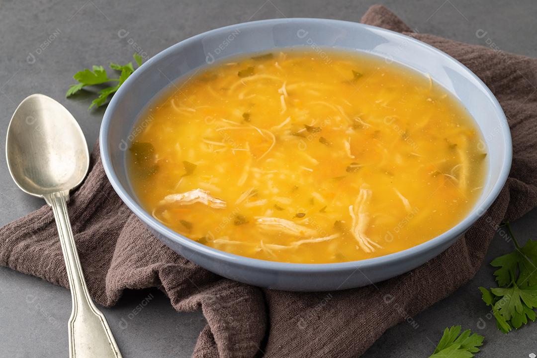 Sopa de galinha em uma tigela sobre fundo de pedra