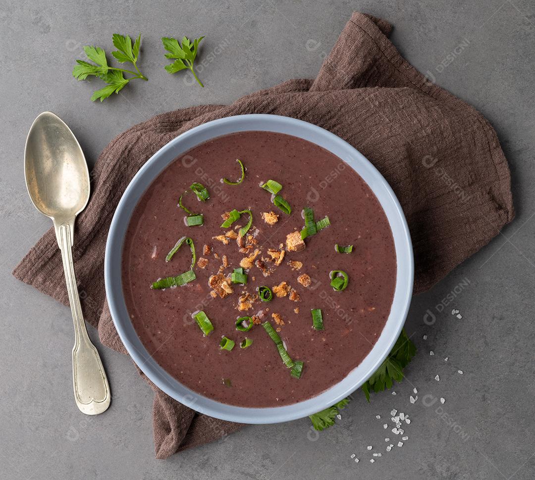 Sopa de feijão preto em uma tigela com tempero sobre fundo de pedra