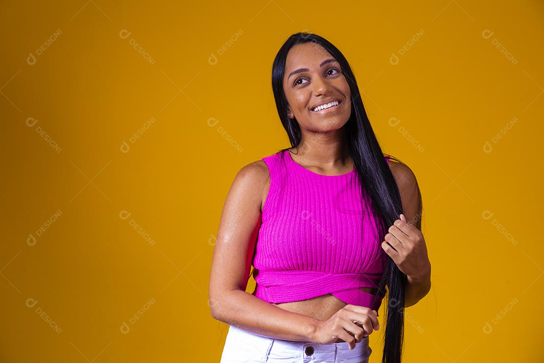 Bela jovem morena com cabelo comprido sorrindo olhando para a câmera