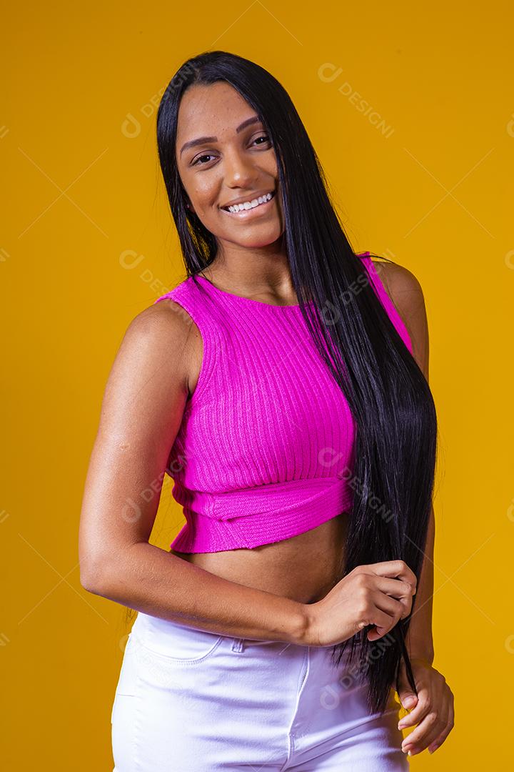 Bela jovem morena com cabelo comprido sorrindo olhando para a câmera