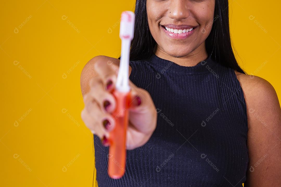 Jovem está escovando os dentes. Mulher jovem com uma escova de dentes