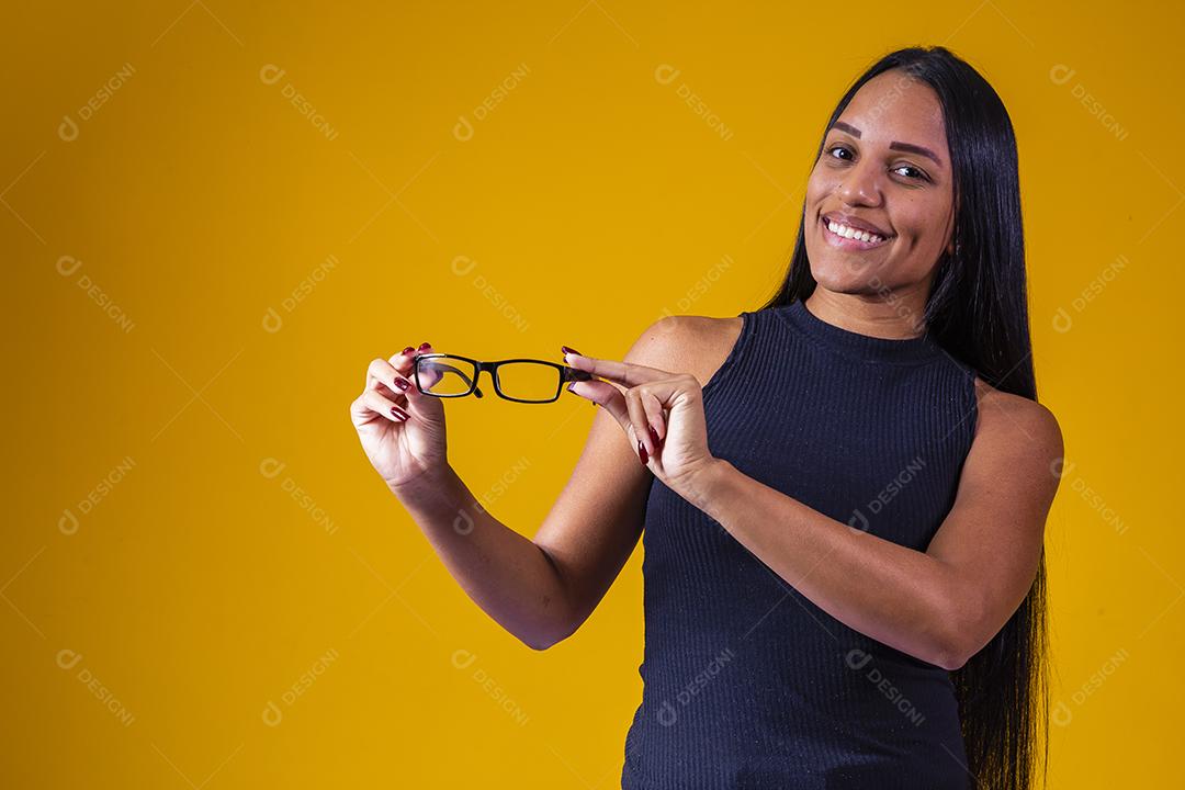 Garota positiva e sorridente segurando óculos.