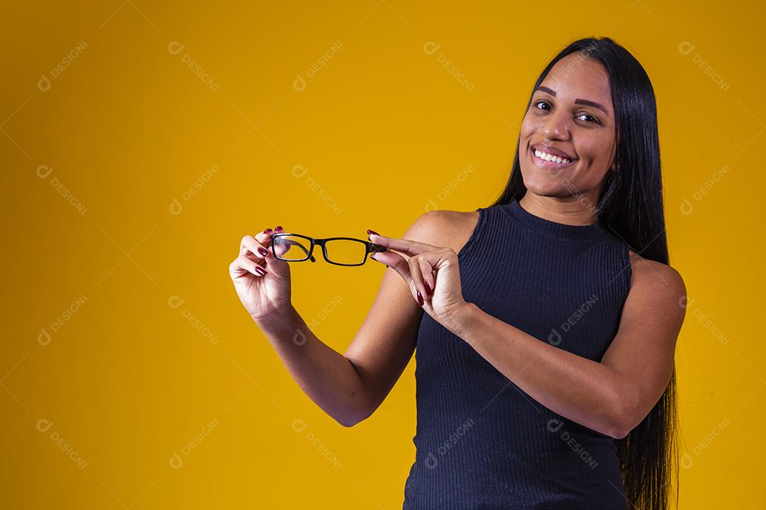 Garota positiva e sorridente segurando óculos.