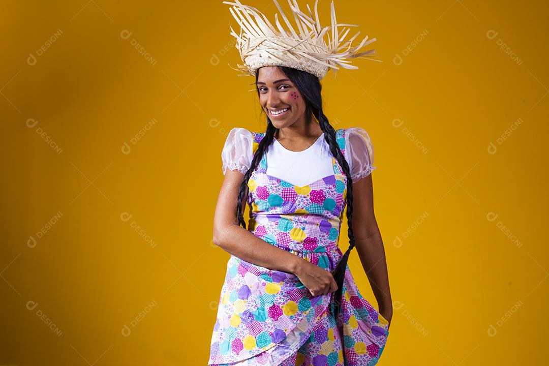 Garota vestida com roupas típicas para a festa junina brasileira dançando