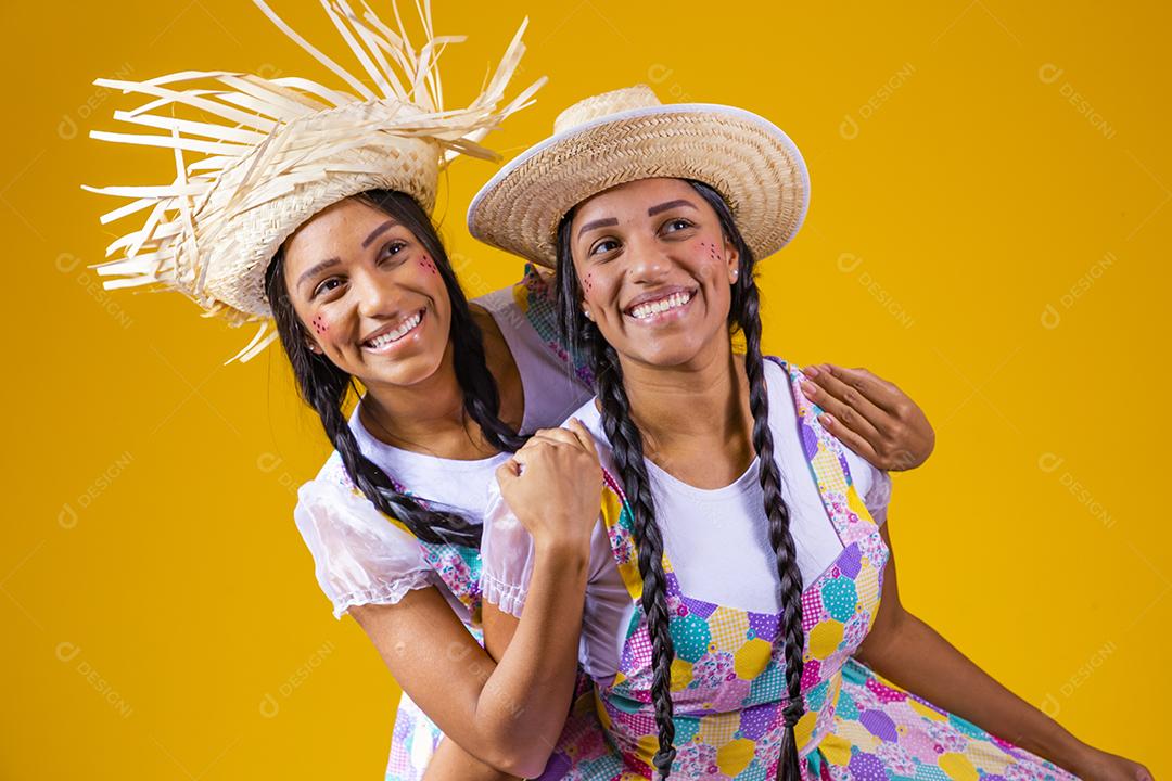 lindas irmãs gêmeas com roupas típicas de festa junina.