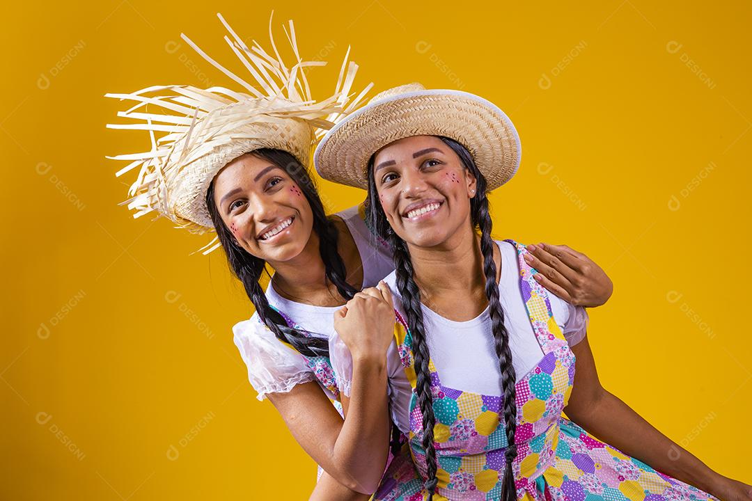 lindas irmãs gêmeas com roupas típicas de festa junina.