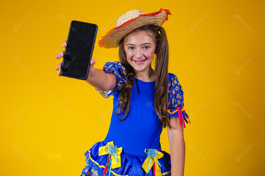 menina branca comemorando o festival de junho no Brasil. Criança com roupa de festa junina apontando
