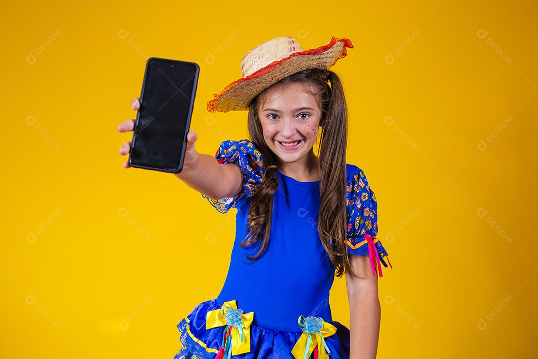 menina branca comemorando o festival de junho no Brasil. Criança com roupa de festa junina apontando
