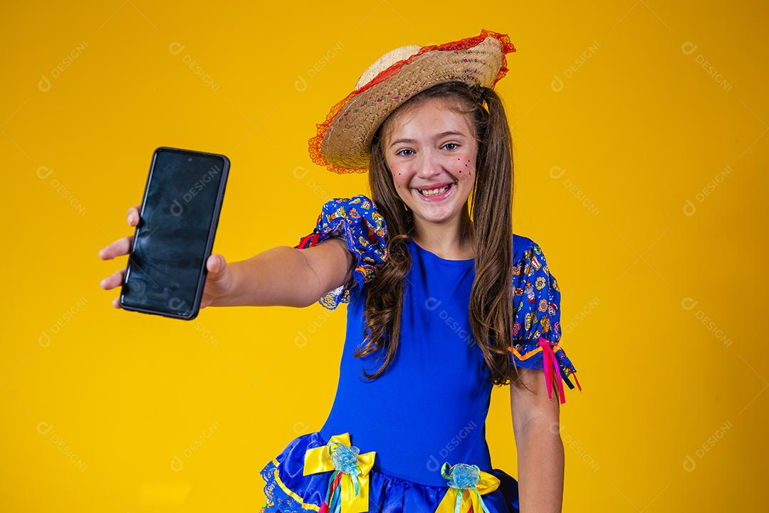 menina menina branca comemorando o festival de junho no Brasil. Criança com roupa de festa junina apontando