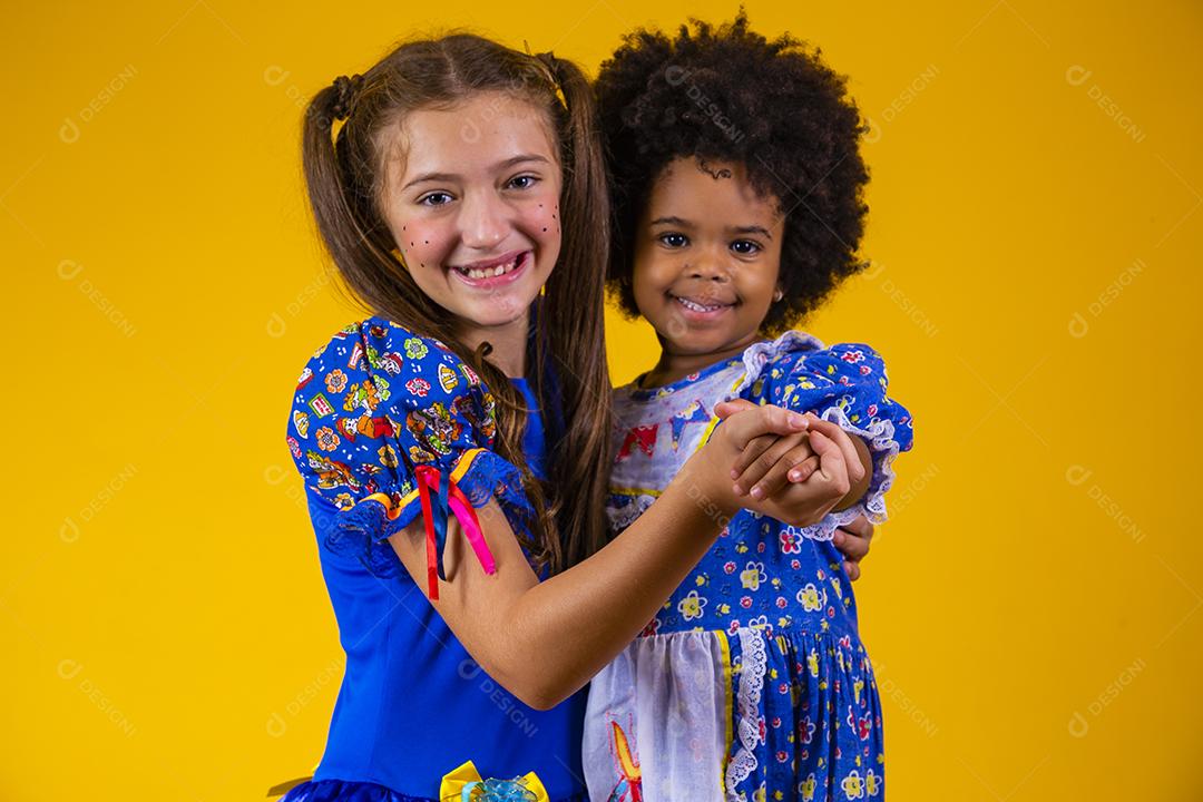 Crianças em roupas típicas da famosa festa brasileira chamada Festa Junina em comemoração ao São João dançando