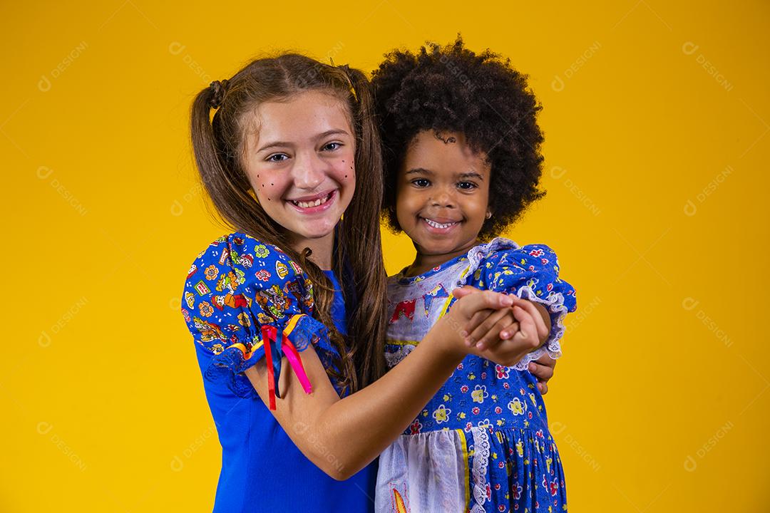 Crianças em roupas típicas da famosa festa brasileira chamada Festa Junina em comemoração ao São João dançando