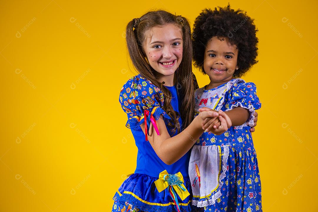 Crianças em roupas típicas da famosa festa brasileira chamada Festa Junina em comemoração ao São João dançando