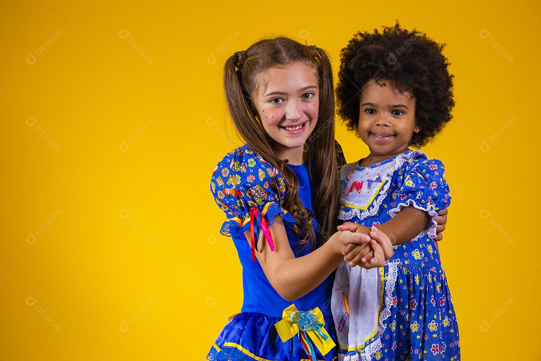 Crianças em roupas típicas da famosa festa brasileira chamada Festa Junina em comemoração ao São João dançando