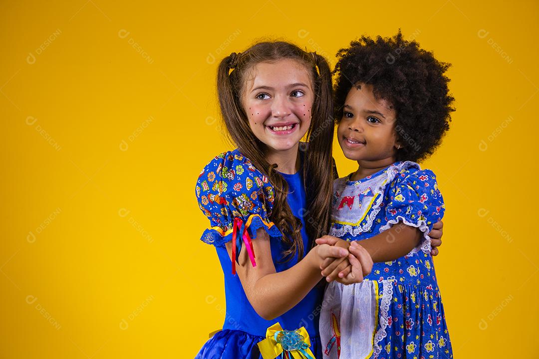 Crianças em roupas típicas da famosa festa brasileira chamada Festa Junina em comemoração ao São João dançando