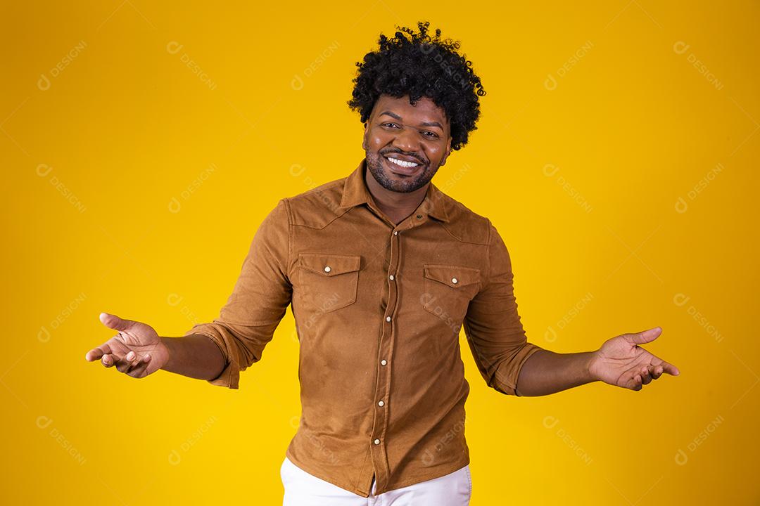 Homem afro bonito sorrindo para a câmera apontando para o lado