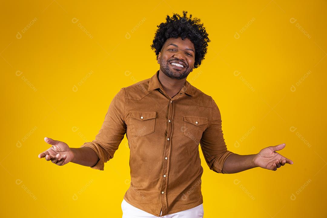 Homem afro bonito sorrindo para a câmera apontando para o lado