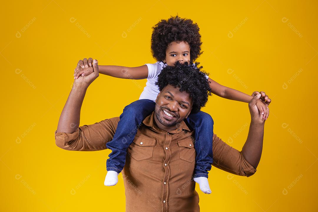 Afro pai e filha em fundo amarelo, sorrindo e brincando. conceito de dia dos pais