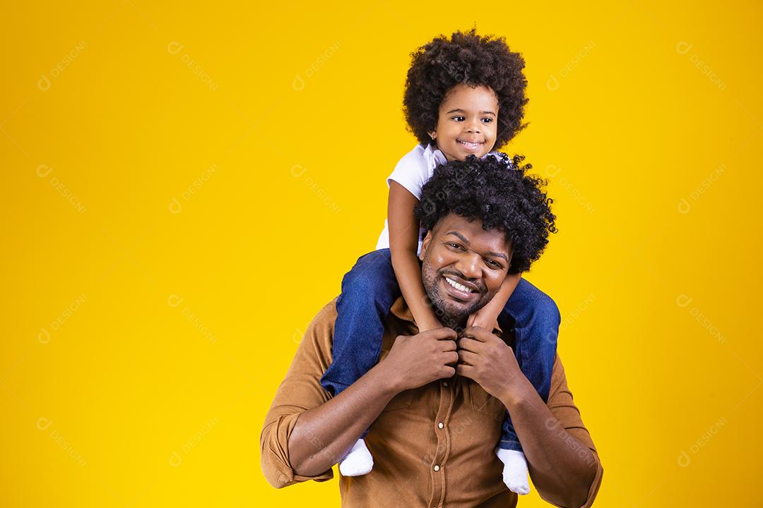 Afro pai e filha em fundo amarelo, sorrindo e brincando. conceito de dia dos pais