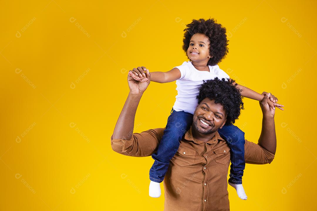 Afro pai e filha em fundo amarelo, sorrindo e brincando. conceito de dia dos pais