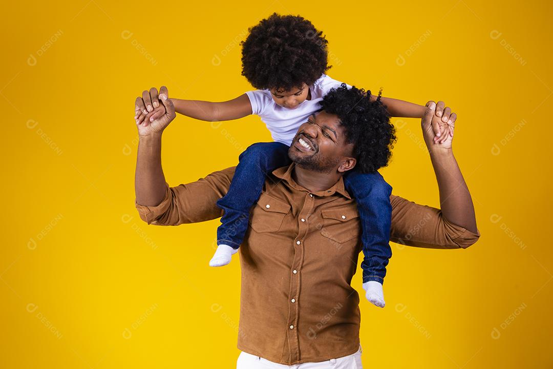 Afro pai e filha em fundo amarelo, sorrindo e brincando. conceito de dia dos pais
