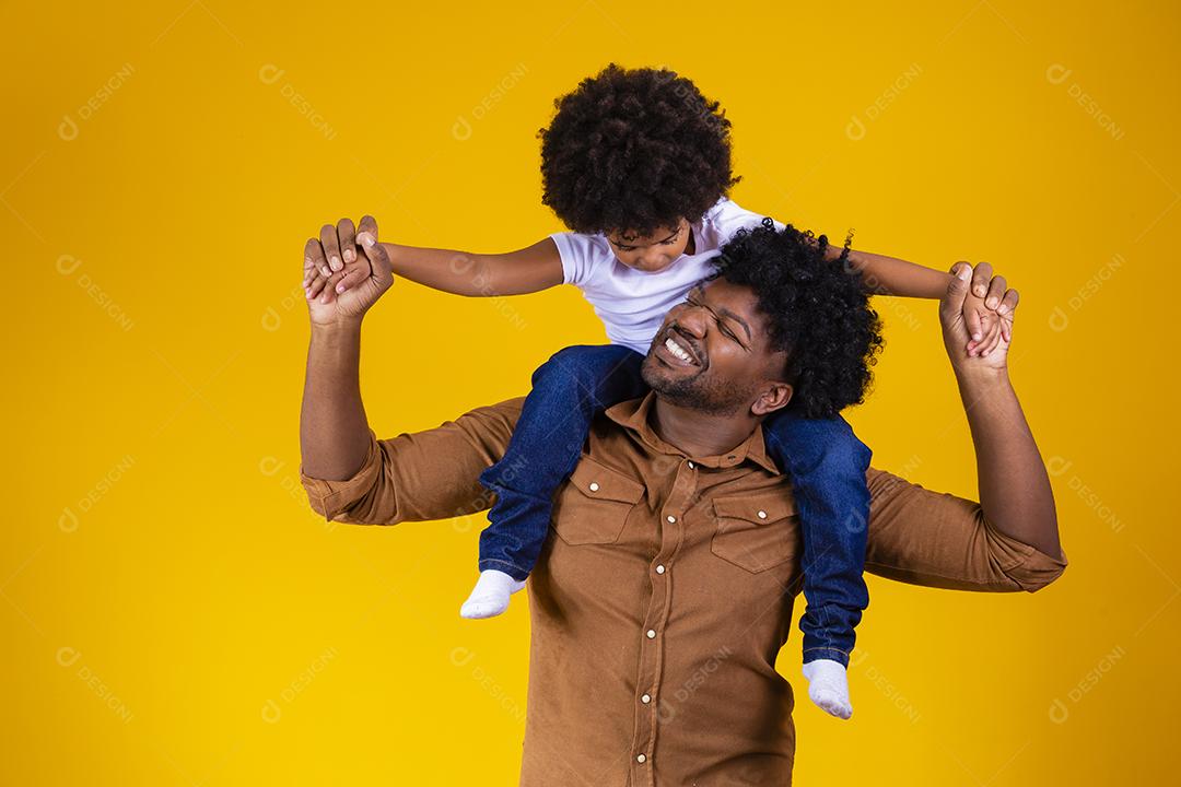 Afro pai e filha em fundo amarelo, sorrindo e brincando. conceito de dia dos pais