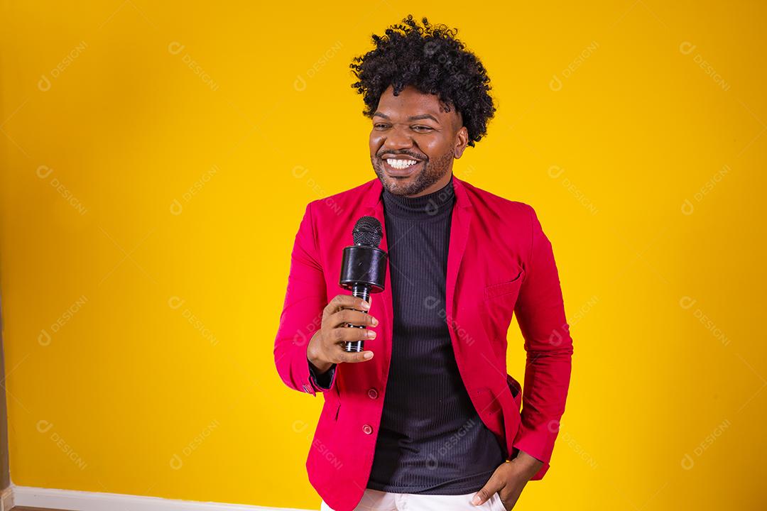 Alegre negro milenar segurando microfone e cantando para a câmera, jovem alegre hipster afro-americano