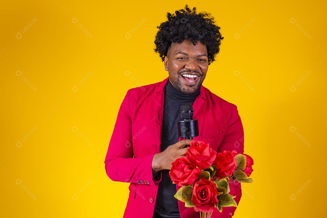 Homem moreno segurando buque de flores vermelho sobre fundo amarelo