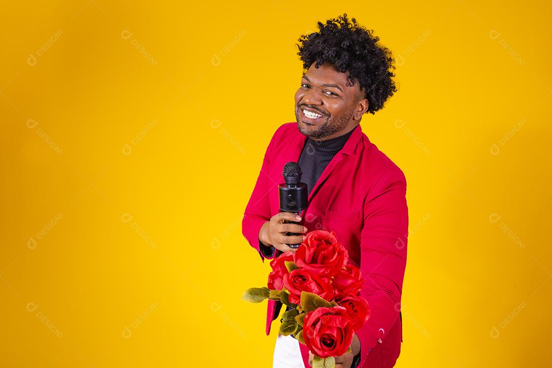 Homem moreno segurando buque de flores vermelho sobre fundo amarelo