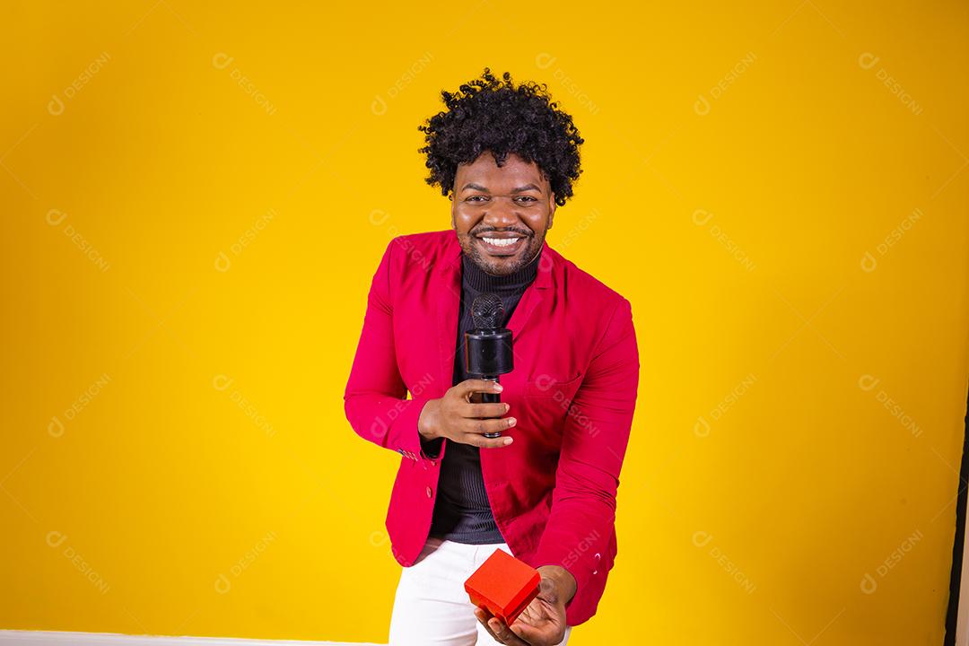 Homem moreno segurando estojo de veludo alianças